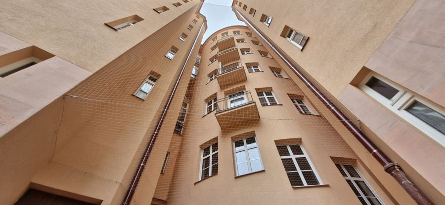 Sítě proti holubům na balkonech dvorní fasády činžovního domu