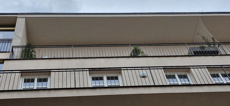 Zasíťované balkony bytového domu, pohled zespodu
