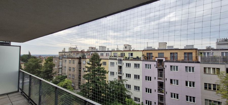 Pohled z balkonu přes ochrannou síť proti holubům