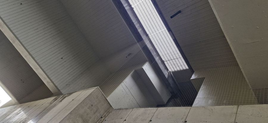 Ochranná síť pod stropem průchodu s betonovými trámy