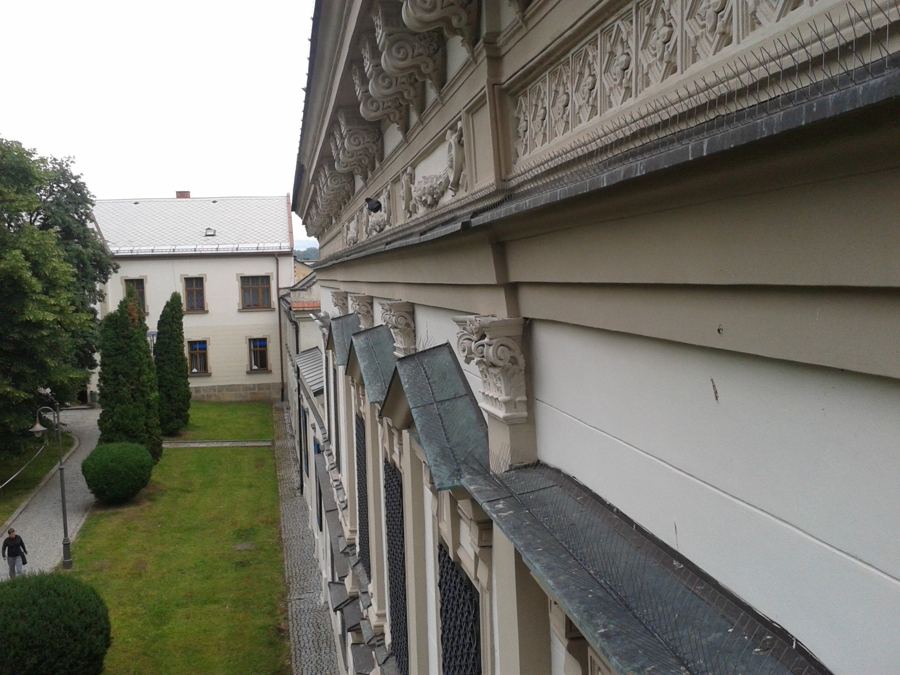 Hroty proti holubům na římse s konzolami historické budovy